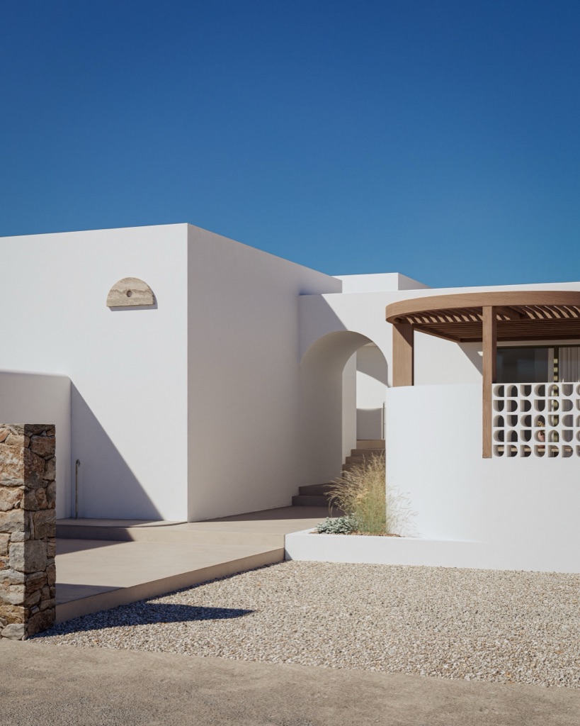 A whitewashed arch and breeze-block wall at the entrance to a residence.