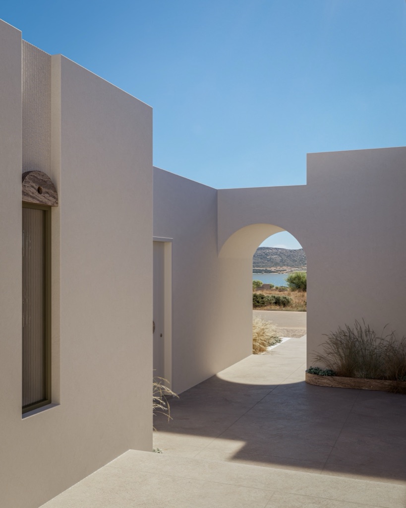 A whitewashed courtyard with a sea-facing arch and Cycladic grasses.